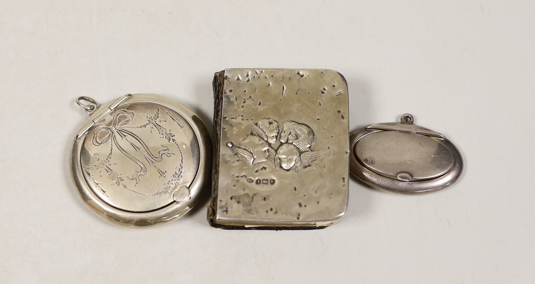 An Edwardian silver mounted silver prayer book, by William Comyns, 54mm and two small silver compacts.
